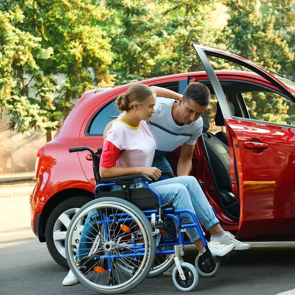 A female being assisted into her modified car - Driving Lessons For People With Physical Impairments and Disabilities on The Gold Coast